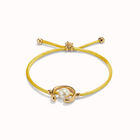 Pulsera de hilonamarillo con perla shell fornitura ba&ntilde;ada en oro 18k.